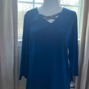 A blue top with a beaded cross design.